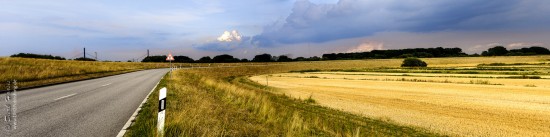 Ein sommersturm braut sich über einer Kurve im Spadenland zusammen